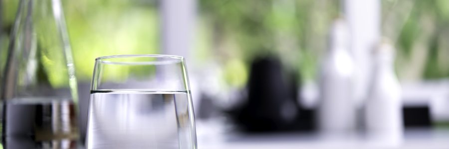 Glass of drinking water on table in kitchen